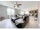 Inviting living room featuring a large sectional sofa, tile flooring, and a view of the kitchen and dining area at 8060 Cherrystone St, Leesburg, FL 34748