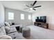 Cozy living room featuring plush seating, contemporary fan, and entertainment center at 8060 Cherrystone St, Leesburg, FL 34748