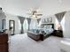 Spacious main bedroom with a ceiling fan, plush carpeting, and abundant natural light from large windows at 8060 Cherrystone St, Leesburg, FL 34748