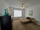 Well-lit bedroom with ceiling fan, dresser, and futon, offering comfort and style at 4401 Thornbriar Ln # 202, Orlando, FL 32822