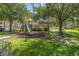 Community playground surrounded by lush grass and mature trees at 4401 Thornbriar Ln # 202, Orlando, FL 32822