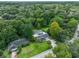 An aerial view shows a home with an enclosed pool, a long drive, mature landscaping, and the surrounding neighborhood at 668 Coral Way, Winter Springs, FL 32708