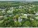 A high aerial shows the neighborhood with mature trees, a pool and glimpses of a lake in the distance at 668 Coral Way, Winter Springs, FL 32708