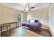 Comfortable bedroom with wood-look floors, ceiling fan, closet, and a sunny window overlooking the yard at 668 Coral Way, Winter Springs, FL 32708