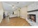 Cozy living room featuring wood floors and a charming stone fireplace at 668 Coral Way, Winter Springs, FL 32708