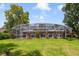 An eye-level shot shows the screened pool with a lush lawn leading up to the enclosure and trees in the background at 668 Coral Way, Winter Springs, FL 32708