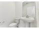 Clean and modern powder room with a pedestal sink, toilet, and white walls, off of the home's entry at 1386 Current Pl, Haines City, FL 33844