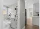 Bathroom with marble-look tile, a rainfall shower head, soaking tub and views into the modern kitchen at 1321 Cloverlawn Ave, Orlando, FL 32806