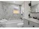 Modern bathroom featuring marble tile, white fixtures, and a bathtub with shower at 1321 Cloverlawn Ave, Orlando, FL 32806