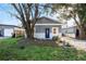 Charming home exterior featuring new paint, a stone foundation, a blue front door, and mature trees at 1321 Cloverlawn Ave, Orlando, FL 32806