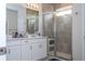 Bathroom with double vanity, walk-in shower, and white cabinets at 16467 Olive Hill Dr, Winter Garden, FL 34787