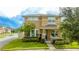 Two-story house with light brown siding, a brick base, and a porch at 16467 Olive Hill Dr, Winter Garden, FL 34787