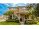 Two-story tan house with a blue door and landscaped yard at 16467 Olive Hill Dr, Winter Garden, FL 34787