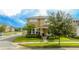 Tan two-story house with a landscaped yard and a blue door at 16467 Olive Hill Dr, Winter Garden, FL 34787