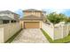 Tan garage with paver driveway and beige vinyl fence at 16467 Olive Hill Dr, Winter Garden, FL 34787