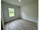 Simple bedroom with wood-look floors and a window at 3325 Sw 165Th Loop, Ocala, FL 34473