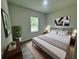 Bedroom with king bed, plant, and wood-look floors at 3325 Sw 165Th Loop, Ocala, FL 34473