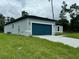 Gray house with a dark-colored garage door and a well-maintained lawn at 3325 Sw 165Th Loop, Ocala, FL 34473