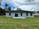 Back of house with sliding glass doors leading to a patio, surrounded by grass at 3325 Sw 165Th Loop, Ocala, FL 34473