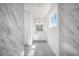 Bright bathroom featuring marble-look tile floors and wall with double sink vanity, and a natural light window at 15062 Sw 63Rd Court Rd, Ocala, FL 34473