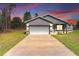 A picturesque house showcasing soft exterior lighting and a spacious driveway, captured at dusk at 15062 Sw 63Rd Court Rd, Ocala, FL 34473