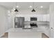 Bright kitchen features stainless steel appliances, white cabinets and island with quartz countertop at 15062 Sw 63Rd Court Rd, Ocala, FL 34473