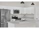 Bright kitchen features stainless steel appliances, white cabinets and island with quartz countertop at 15062 Sw 63Rd Court Rd, Ocala, FL 34473