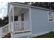 Inviting blue tiny home featuring a covered porch and white railings, blending comfort and style at 575 2Nd St, Oviedo, FL 32765