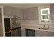 Well lit kitchen featuring grey cabinets and stainless steel appliances at 575 2Nd St, Oviedo, FL 32765