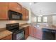 Modern kitchen with wood cabinets and black appliances at 11757 Fitzgerald Butler Rd, Orlando, FL 32836