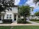 Two-story townhome with light gray siding, landscaping, and a welcoming front porch at 1366 Ponce Dr, Celebration, FL 34747