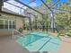 Screened pool with stairs and patio, surrounded by lush landscaping at 143 Brunswick Dr, Davenport, FL 33837