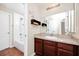 Bright bathroom with cherry vanity, tub/shower combo with tiled surround and white toilet at 15558 Sandfield Loop, Winter Garden, FL 34787