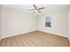 Light-filled bedroom with wood floors, ceiling fan and a window overlooking the backyard at 15558 Sandfield Loop, Winter Garden, FL 34787