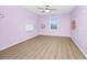 Lilac bedroom with plank floors, ceiling fan and a window providing natural light at 15558 Sandfield Loop, Winter Garden, FL 34787