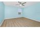 This bedroom has wood floors, ceiling fan, window and pale blue walls at 15558 Sandfield Loop, Winter Garden, FL 34787