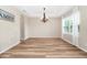 Bright dining room featuring hardwood floors, a modern chandelier, and a large window at 15558 Sandfield Loop, Winter Garden, FL 34787