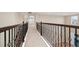 Hallway with decorative iron and wood railing overlooking the first floor of the house at 15558 Sandfield Loop, Winter Garden, FL 34787