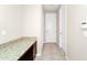 Hallway features granite-topped cabinets for storage, tile floors and several interior doors at 15558 Sandfield Loop, Winter Garden, FL 34787