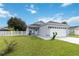 Cute one-story house with a white picket fence and a two-car garage at 805 Nelson Dr, Kissimmee, FL 34758