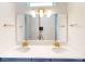 Close-up of bathroom with double sinks, white countertop, blue cabinets, and gold fixtures at 9982 Fiddley Aly, Orlando, FL 32827