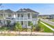 Two-story home featuring a covered porch, balcony, and lush landscaping at 9982 Fiddley Aly, Orlando, FL 32827