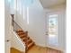 Bright foyer featuring a staircase with wooden steps, black railings, and a glass front door at 9982 Fiddley Aly, Orlando, FL 32827