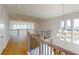 Open hallway with hardwood floors, black metal railing, and an elegant chandelier at 9982 Fiddley Aly, Orlando, FL 32827