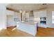 Modern kitchen with white cabinets, stainless steel appliances, a large center island, and hardwood floors at 9982 Fiddley Aly, Orlando, FL 32827