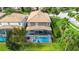 Aerial view of backyard with pool and screen enclosure surrounded by lush greenery at 1427 Rolling Fairway Dr, Davenport, FL 33896