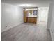 An empty living room with wood floors leading to an adjacent kitchen with bar-stool seating at 1250 S Denning Dr # 122, Winter Park, FL 32789