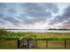 Relaxing backyard view of a serene lake, framed by a decorative black metal fence at 16695 Broadwater Ave, Winter Garden, FL 34787