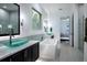 Modern bathroom with soaking tub, dual vessel sinks, and bright lighting at 16695 Broadwater Ave, Winter Garden, FL 34787