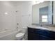 A well-lit bathroom with a tub, granite counter top, dark cabinets, and white tile surround at 16695 Broadwater Ave, Winter Garden, FL 34787